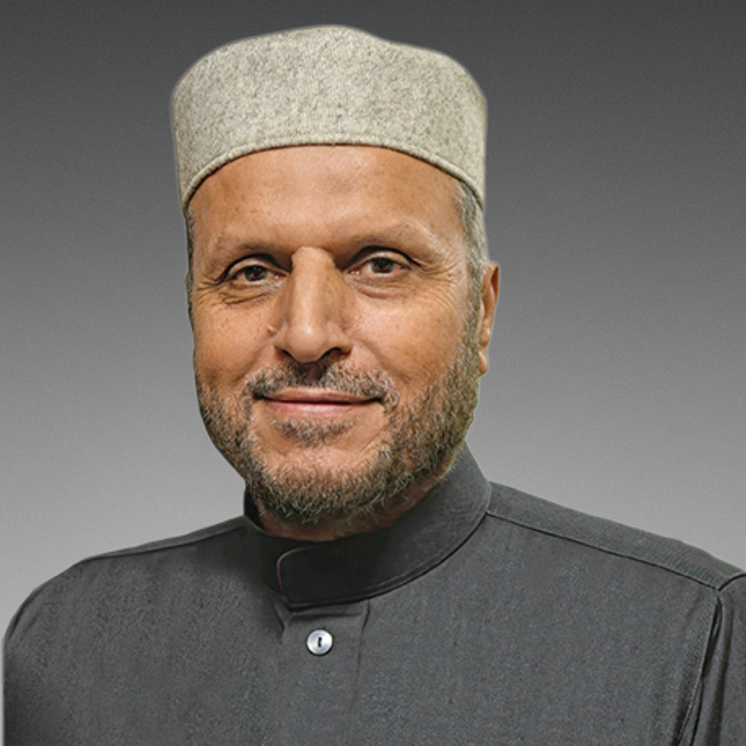 Smiling bearded man wearing gray cap and robe